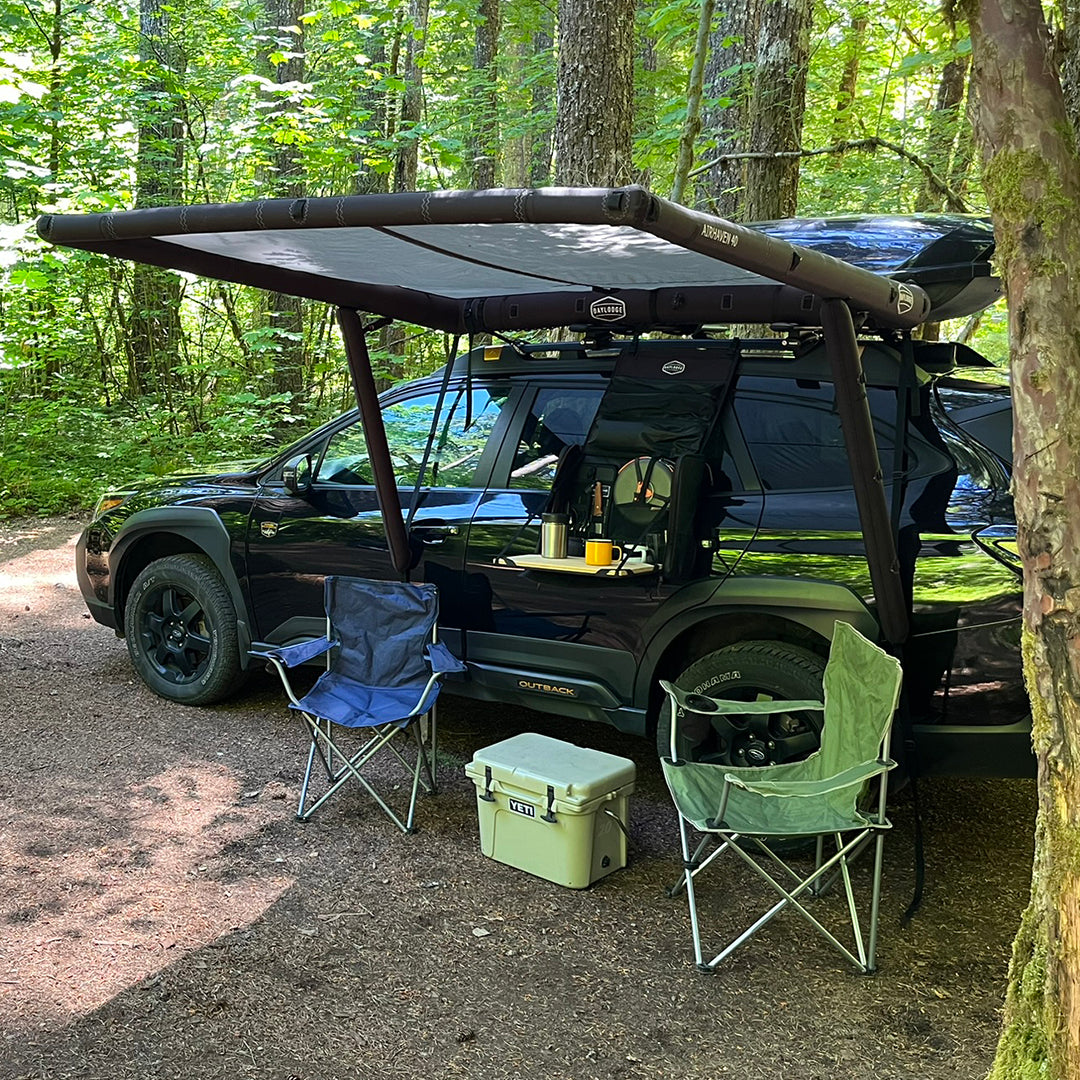 SUV with a rooftop tent and AirHaven 40 awning in a forest