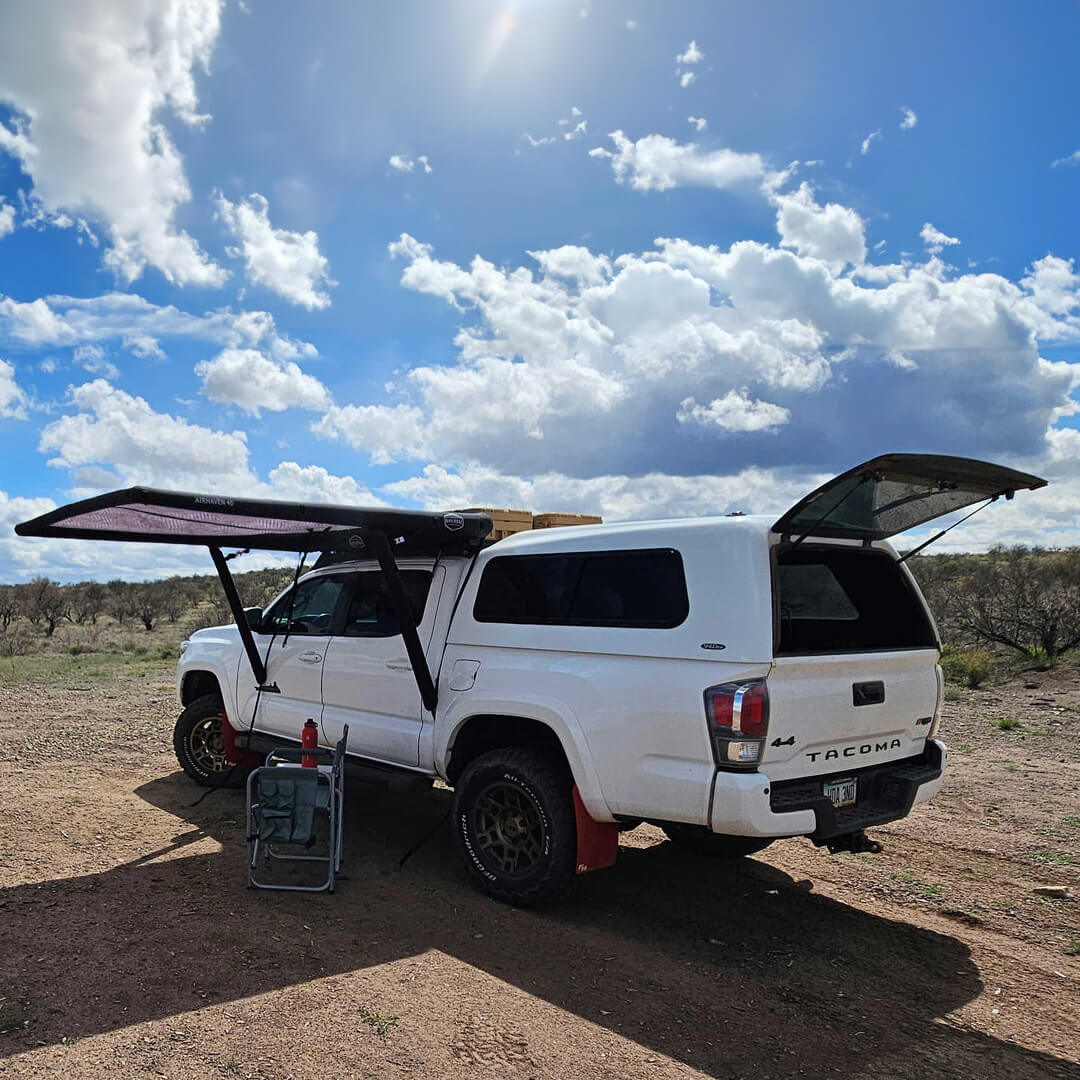 Toyota Tacoma with cab setup for camping with vehicle awning and gear 