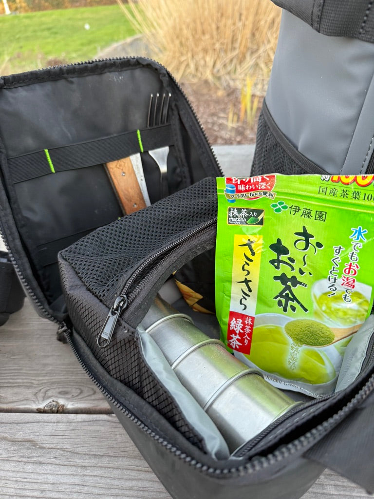 Cold Cube Soft Cooler unzipped with green tea, a thermos and utensils inside