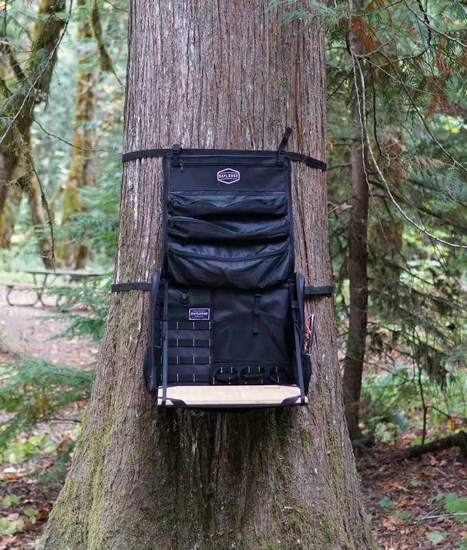 Workspace camp kitchen strapped around a cedar tree with its lid straps