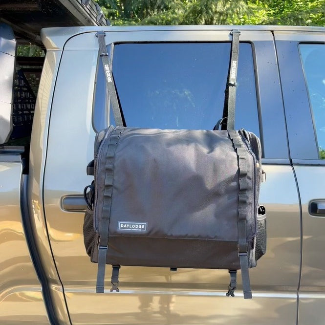 Workspace camp kitchen hanging from a pickup truck rear door on vinyl-coated flat-hook to G-hook straps