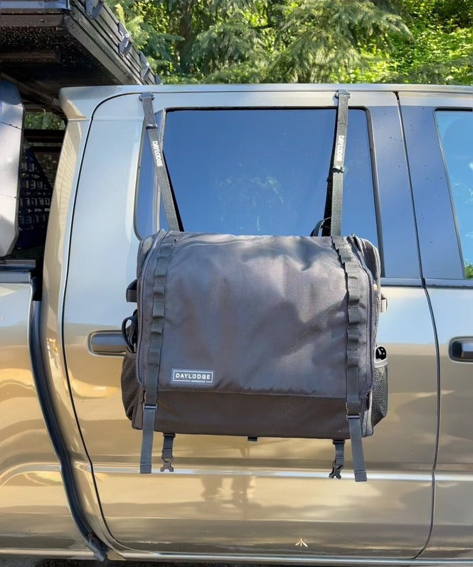 Workspace camp kitchen hanging from a pickup truck rear door on vinyl-coated flat-hook to G-hook straps