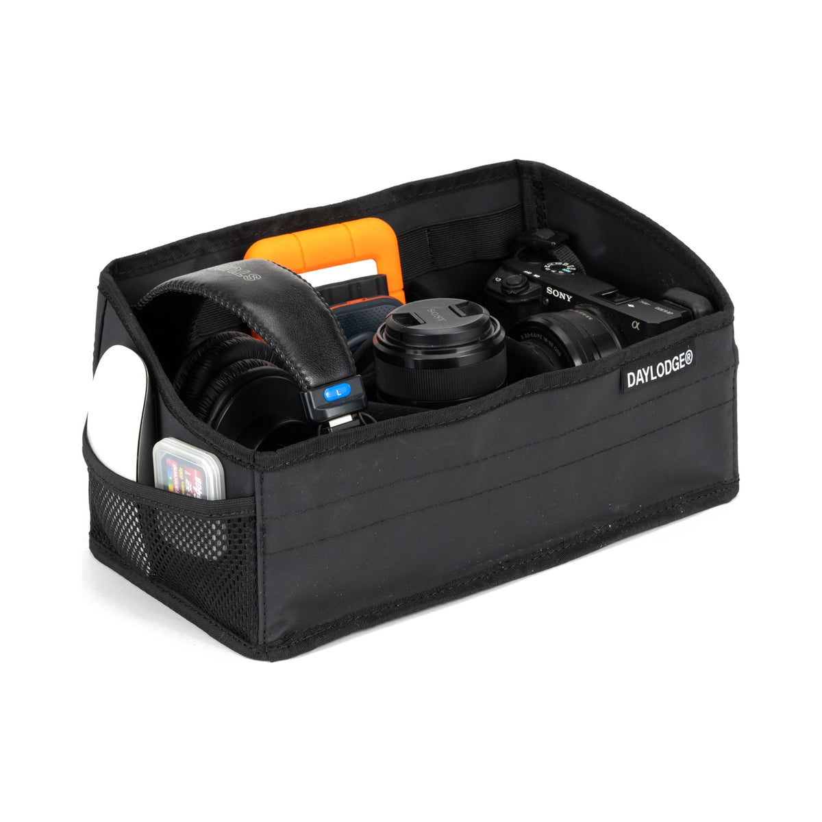 Workspace tray packed with a camera, lens, headphones, hard drive and SD cards